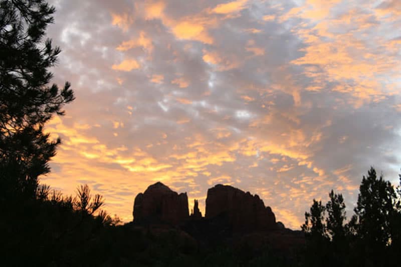 Soft fluffy clouds above Cathedral Rock at sunrise. View is from our property - Sedona Cathedral Hideaway BnB and Spa
